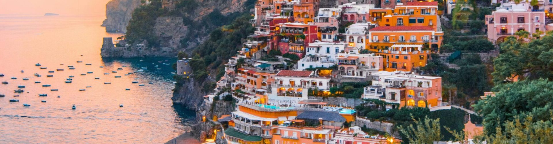 Breathtaking view of Positano's colorful cliffside homes at sunset.